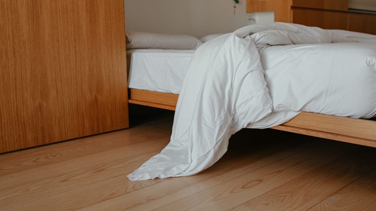 The leg of a bed frame where it meets a wooden floor