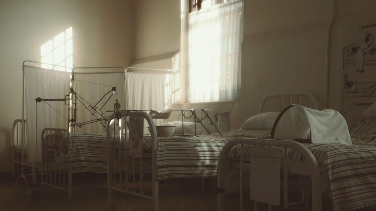 An empty hospital bed in a clinical room