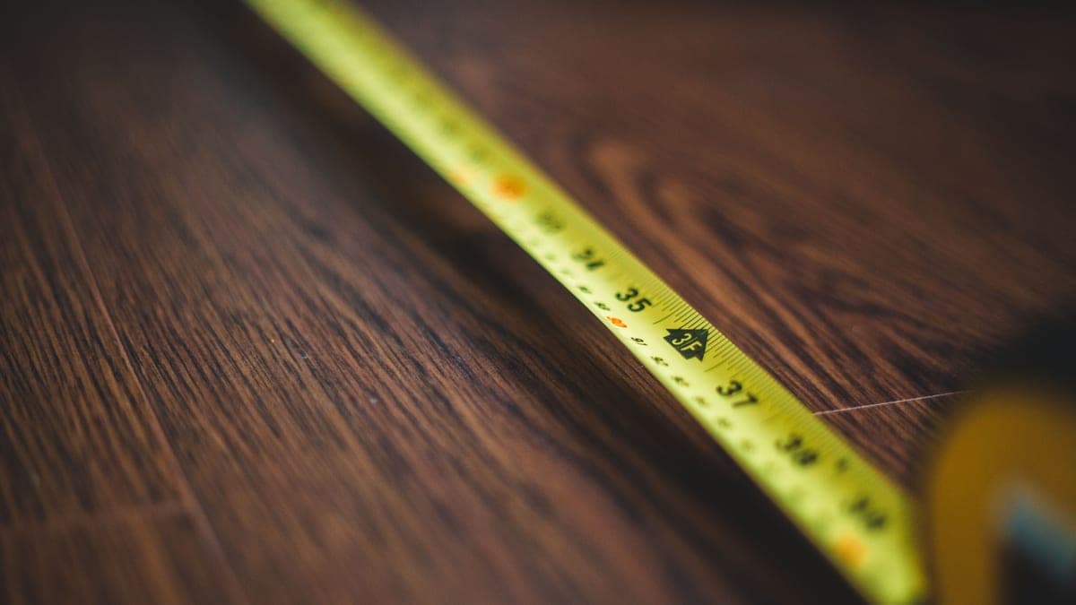 A tape measure resting on a wooden floor
