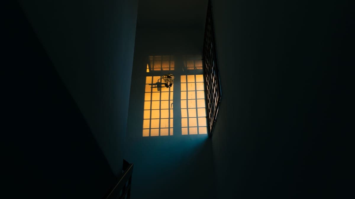 A dim hallway at night with a low light near the floor